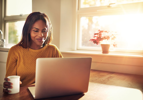 Woman working at her computer with a cup of coffee