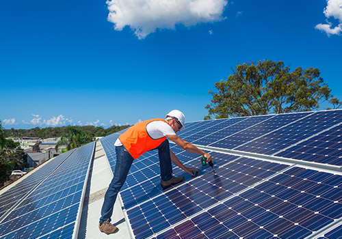 Man on a roof installing solar panels 